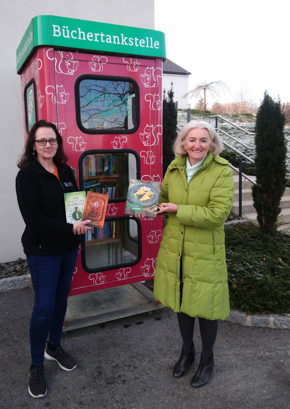 Zu sehen ist: zwei Damen vor der Büchertankstelle