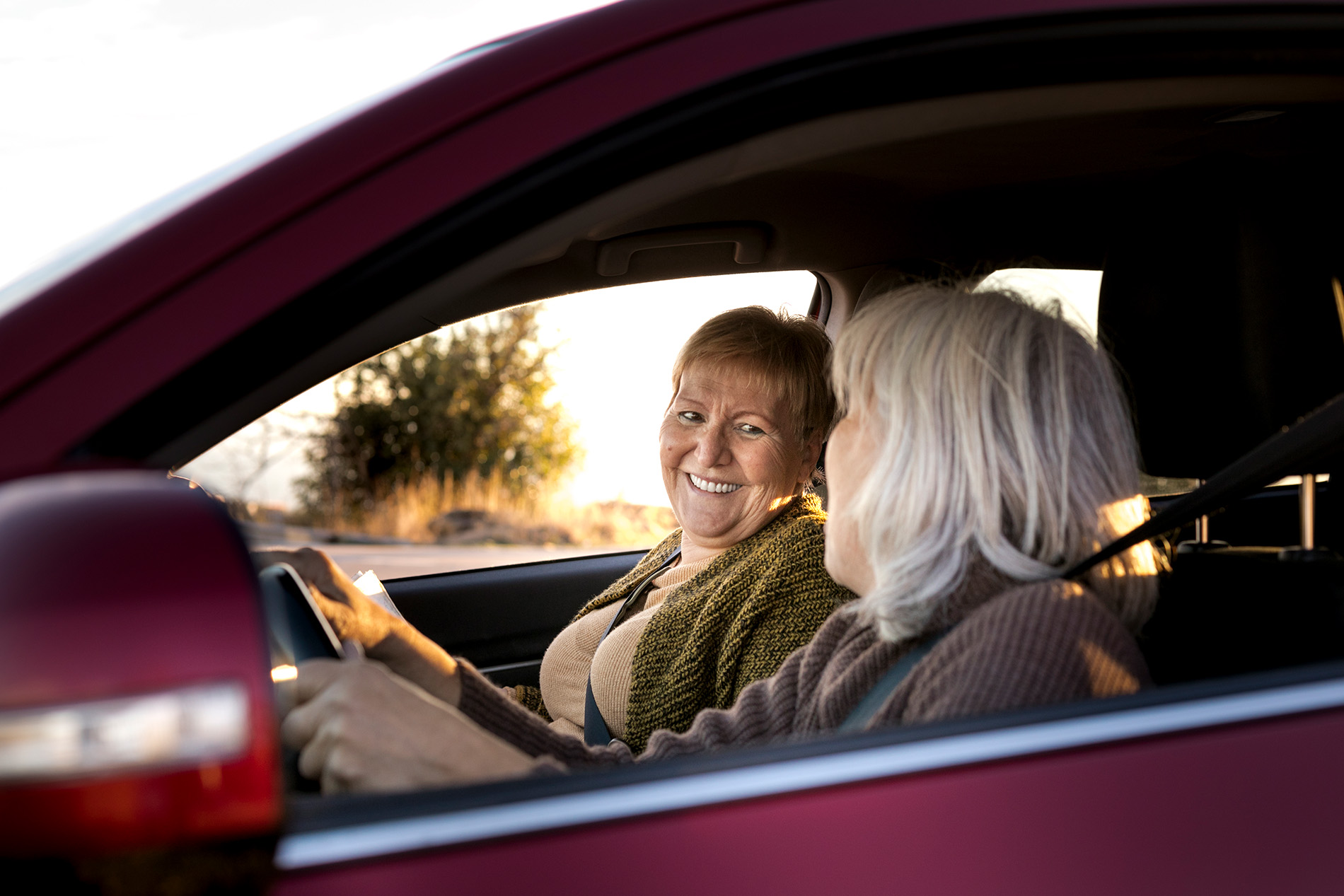 two-senior-women-car-driving-going-adventure-nature